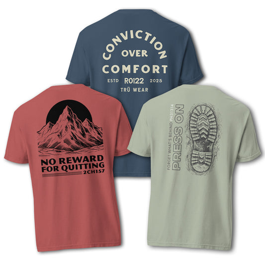 Three TRŪ Wear Comfort Colors garment-dyed tees displayed together — Conviction Over Comfort (Midnight blue), No Reward For Quitting (Red), and Press On (Bay/sage). Back-print designs visible. Christian men's Scripture verse code apparel bundle.